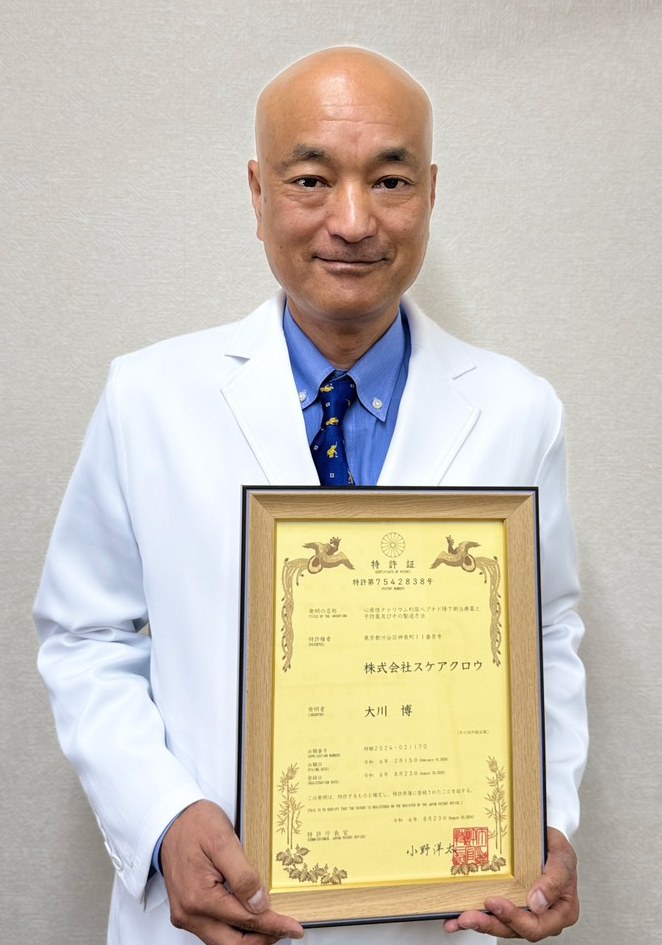 Hiroshi Okawa, President and CEO of Scarecrow Inc., holding a patent certificate